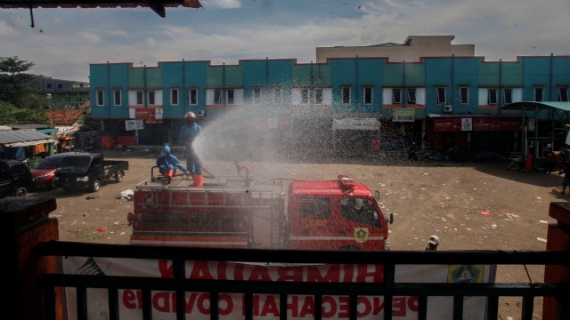 Petugas Pemadam Kebakaran menyemprotkan cairan disinfektan di area Pasar Cileungsi, Kabupaten Bogor, Jawa Barat. Foto: Yulius Satria Wijaya/ANTARA FOTO