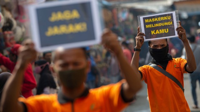 Petugas pengelola pasar berkampanye pencegahan COVID-19 dengan membawa poster berisi pesan di Pasar Jatinegara, Jakarta, Kamis (11/6). Foto: Aditya Pradana Putra/Antara Foto