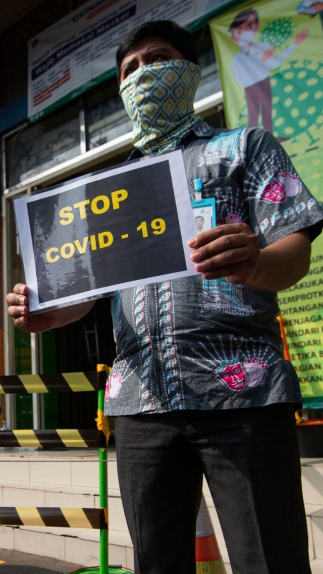 Petugas pengelola pasar berkampanye pencegahan COVID-19 dengan membawa poster berisi pesan di Pasar Jatinegara, Jakarta, Kamis (11/6). Foto: Aditya Pradana Putra/Antara Foto