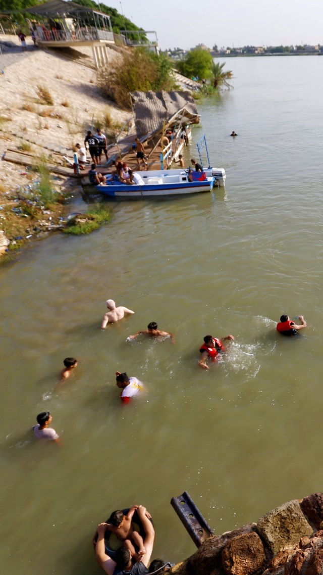 Anak-anak berenang di Sungai Tigris, Baghdad, Irak, Kamis (11/6). Foto: Khalid al-Mousily/Reuters