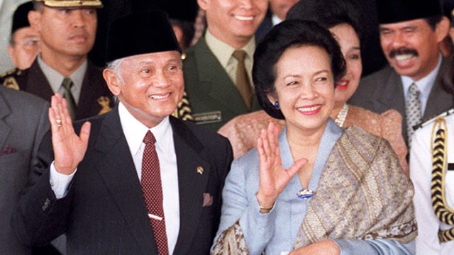 Presiden Indonesia B.J. Habibie dan istrinya Ainun Habibie melambai kepada wartawan di gedung Parlemen di Jakarta, 21 September 1999, setelah ia memberikan penjelasan tentang kebijakan pemerintah tentang Timor Lorosa'e kepada anggota Parlemen. Foto: AFP/OKA BUDHI