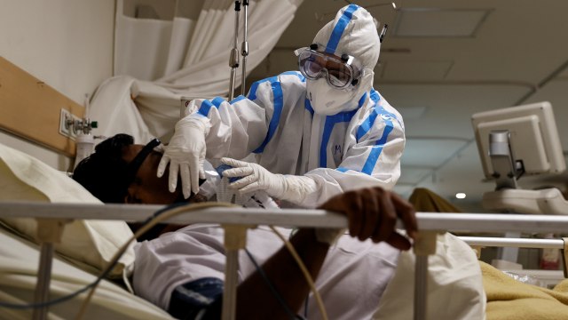 Pekerja medis merawat seorang pasien yang menderita penyakit COVID-19 di New Delhi, India, (28/5). Foto: Danish Siddiqui/REUTERS