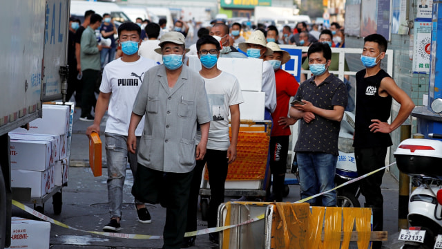 Orang-orang memakai masker di dalam pasar makanan laut Jingshen, di Beijing, China. Foto: Thomas Peter/REUTERS