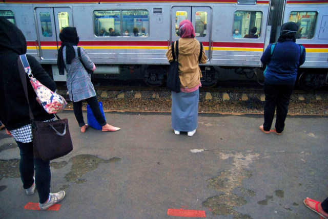 Sejumlah calon penumpang KRL Commuter Line menunggu kereta dengan berdiri sesuai tanda jarak fisik di Stasiun Bogor, Jawa Barat, Senin (15/6). Foto: Arif Firmansyah/Antara Foto
