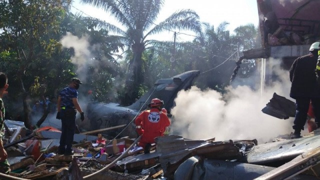 Petugas memadamkan api di lokasi jatuhnya pesawat TNI AU di Kabupaten Kampar yang berbatasan dengan Kota Pekanbaru, Senin pagi (15/6). Foto: ANTARA