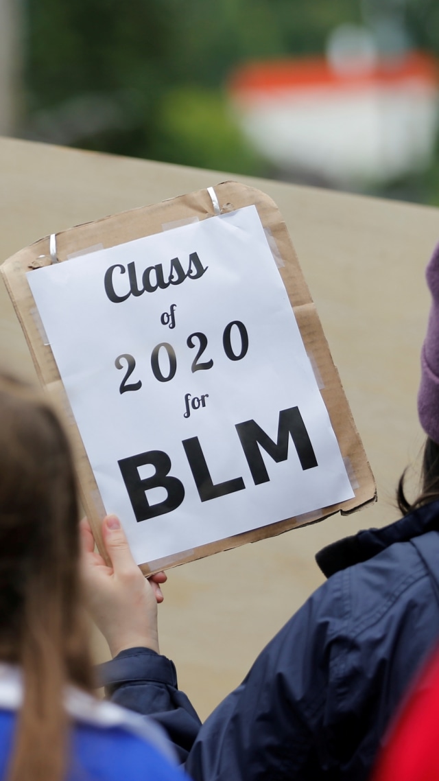 Seorang siswa lulusan SMA Nathan Hale mengangkat poster bertuliskan "Class of 2020 for BLM" saat melakukan unjuk rasa menentang ketidaksetaraan ras. Foto: Lindsey Wasson/Reuters