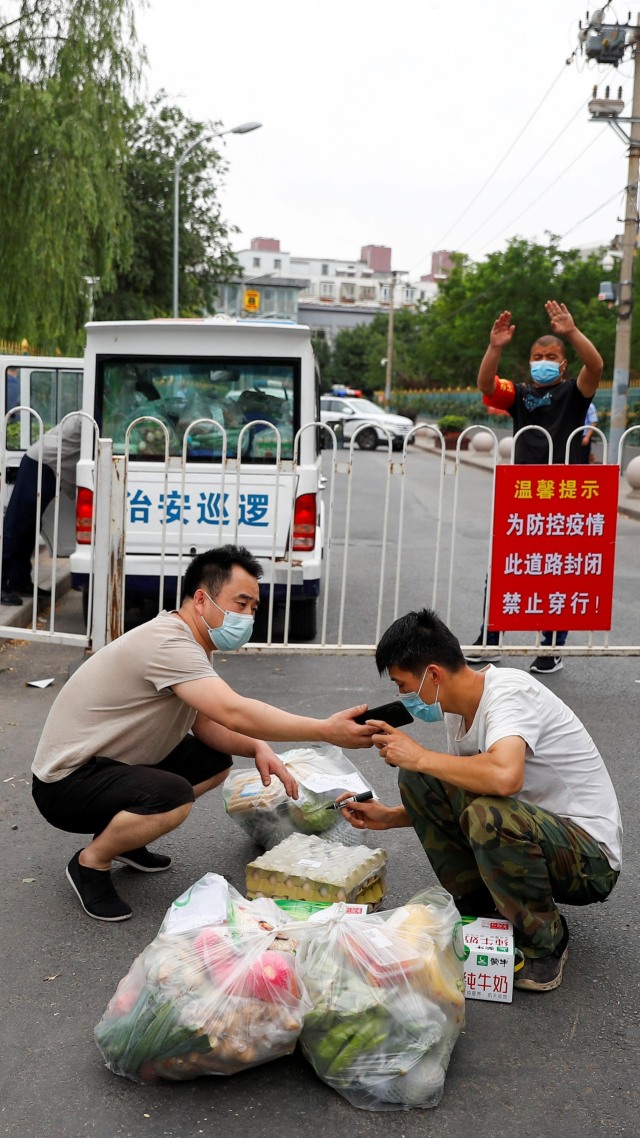 Sejumlah warga menyiapkan makanan yang akan dikirim ke kompleks perumahan yang lockdown, di distrik Fengtai, Beijing, China. Foto: Thomas Peter/REUTERS