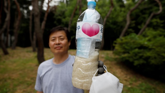 Park Jung-oh, kepala kelompok pembelot Korea Utara menunjukkan botol yang berisi beras dan masker untuk dikirimkan ke Korea Utara di Seoul, Korea Selatan. Foto: Kim Hong-Ji / REUTERS