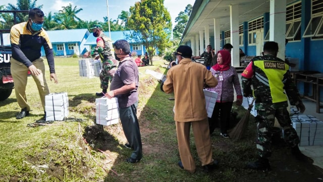 Petugas memberi makanan ke rumah warga yang mengisolasi diri di Dusun Huta 2 Negori Tanjung Hataran, Kecamatan Bandar Haluan, Kabupaten Simalungun, Sumut. Foto: Dok. Istimewa