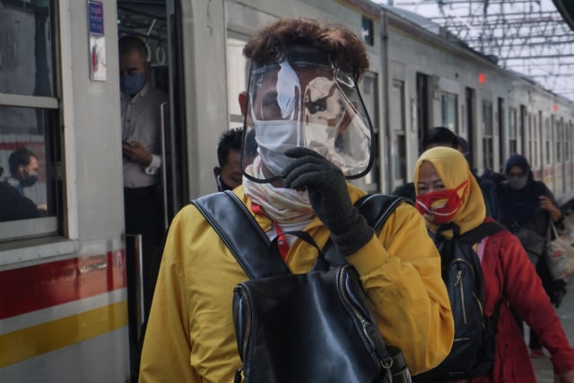 Penumpang kereta rel listrik (KRL) commuter line menggunakan pelindung wajah (face sheilds) turun dari kereta di Stasiun Manggarai, Jakarta. Foto: Fanny Kusumawardhani/kumparan