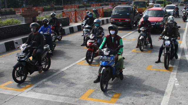 Pengendara motor berhenti di belakang garis untuk menjaga jarak antarpengendara di Karanglo, Malang, Jawa Timur, Kamis (11/6). Foto: Ari Bowo Sucipto/Antara Foto