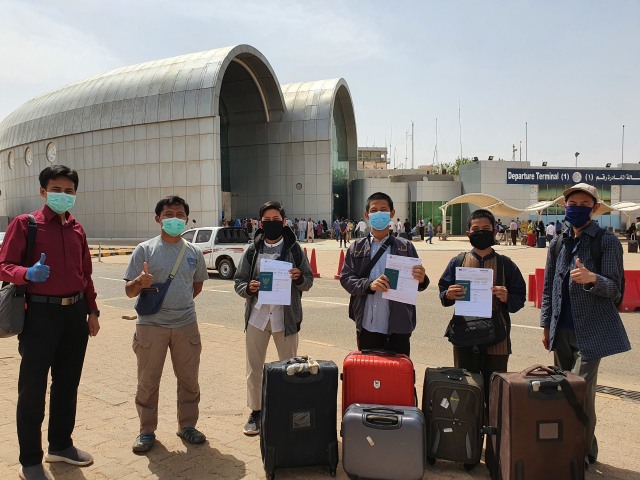 Ketiga mahasiswa yang pulang memegang dokumen, berfoto bersama Satgas PPI Sudan dan Satgas KBRI Khartoum di Bandara Internasional Khartoum. Foto: Muhammad Nasrullah