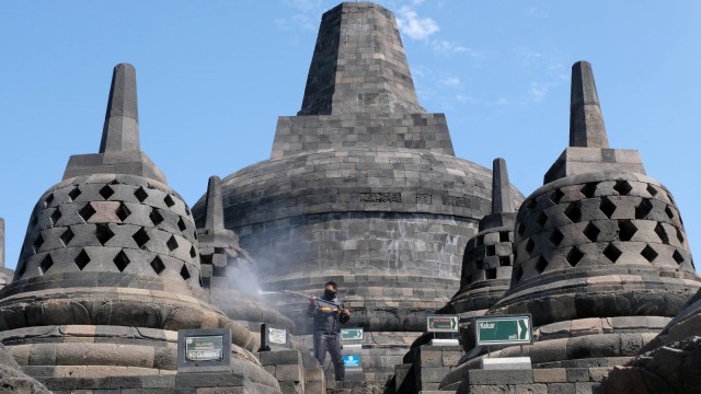 Petugas menyemprotkan air saat membersihkan abu vulkanik erupsi gunung Merapi di Candi Borobudur, Magelang, Jawa Tengah, Senin(22/6). Foto: Anis Efizudin/Antara Foto