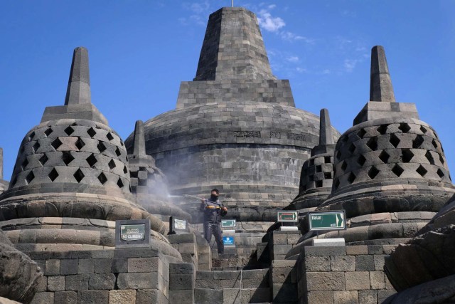 Petugas Balai Konservasi Borobudur (BKB) menyemprotkan air saat membersihkan abu vulkanik erupsi gunung Merapi di candi Borobudur, Magelang, Jawa Tengah. Foto: ANIS EFIZUDIN/ANTARA FOTO