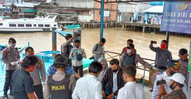 Polisi memeriksa barabg bawaan penumpang kapal yang berlabu di Tanjab Barat, Jambi. Foto: Jambikita.id