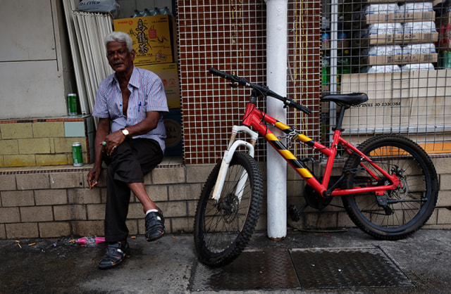 Laki-laki India sedang duduk merokok ditemani kaleng minuman dekat sepeda | doc : pribadi