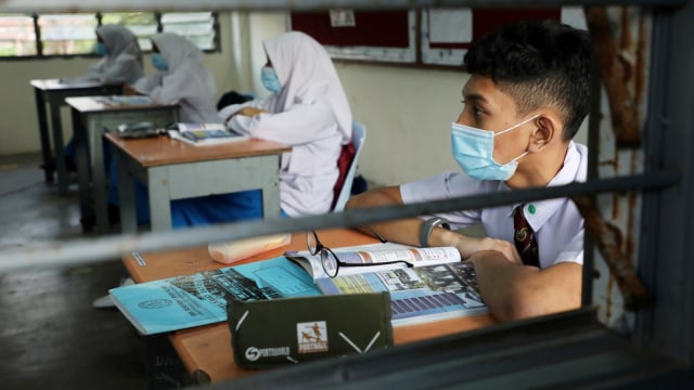 Pelajar mengenakan masker saat kegiatan belajar di ruang kelas pada salah satu  sekolah menengah di Shah Alam, Malaysia, Rabu (24/6). Foto: Lim Huey Teng/Reuters