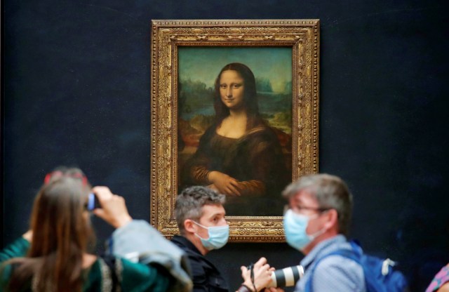 Sejumlah wartawan yang mengenakan masker berdiri di depan lukisan "Mona Lisa" di Museum Louvre, Paris, Prancis, Selasa (23/6). Foto: Charles Platiau/Reuters