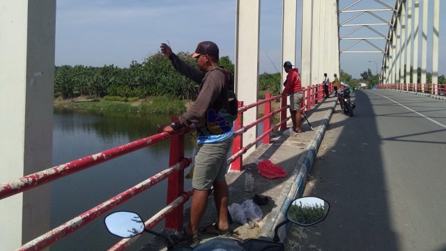 Suasana Jembatan Bengawan Solo di Kecamatan Malo Kabupaten Bojonegoro, Kamis (25/06/2020), yang ramai dikunjungan para pemancing yang memancing dari atas jembatan tersebut.