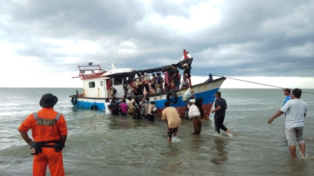 Warga turunkan pengungsi Rohingya dari atas kapal ke daratan.  Foto: Dok. Istimewa