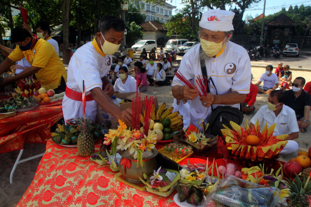 Umat mempersembahkan sesaji saat melaksanakan tradisi peh cun di pinggir pantai Kuta, Bali - ZTE