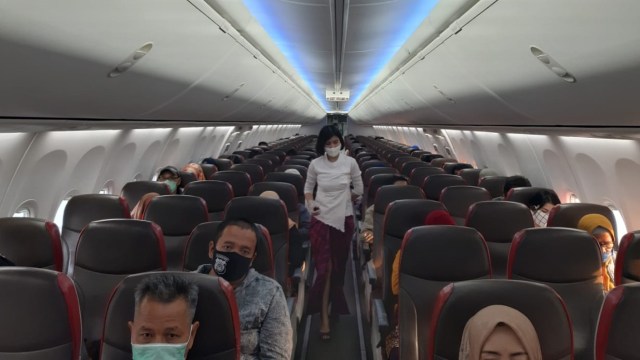 Sejumlah penumpang menggunakan masker saat beada di dalam kabin pesawat Lion Air.  Foto: Lion Air