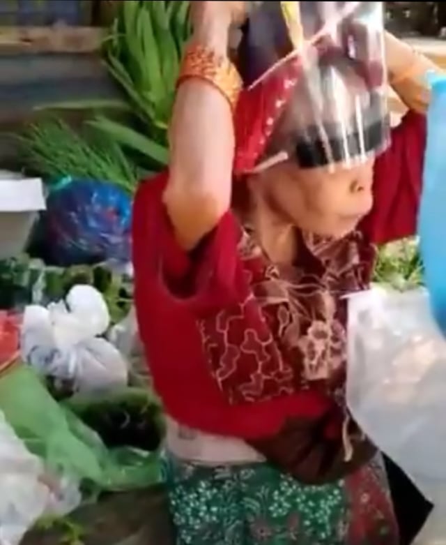 Kocak, nenek penjual sayur ini pakai Face Shield terbalik. (Foto: Twitter/Tangkapan Layar @jawafess)
