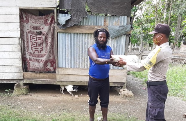 Seorang warga Kampung Biha Nabire yang terdampak corona menerima bantuan beras 1 kilogram dari Kapolri. (Dok Polda Papua)