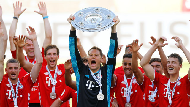 Momen Bayern Muenchen jadi juara Bundesliga 2019/20. Manuel Neuer angkat trofi. Foto: REUTERS / Kai Pfaffenbach / Pool DFL