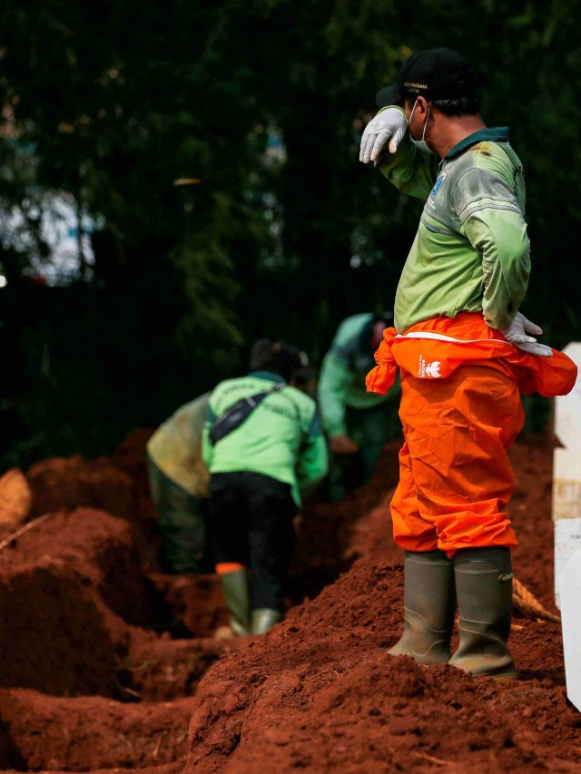 Salah satu petugas beristirahat usai memakamkan jenazah pasien virus corona di pemakaman Pondok Ranggon, Jakarta Timur. Foto: Willy Kurniawan/REUTERS