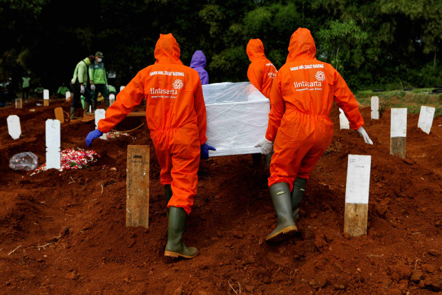 Petugas membawa peti jenazah pasien virus corona untuk dimakamkan di pemakaman Pondok Ranggon, Jakarta Timur. Foto: Willy Kurniawan/REUTERS