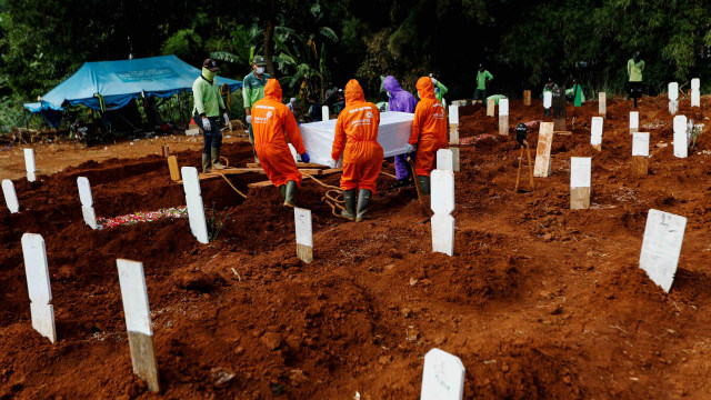 Petugas saat memakamkan jenazah pasien virus corona di pemakaman Pondok Ranggon, Jakarta Timur. Foto: Willy Kurniawan/REUTERS