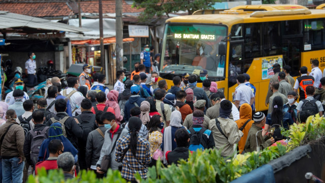 Sejumlah warga mengantre masuk ke dalam bus yang disediakan pemerinatah di Stasiun KA Bogor di Kota Bogor, Jawa Barat, Senin (29/6). Foto: Aditya Pradana Putra/Antara Foto