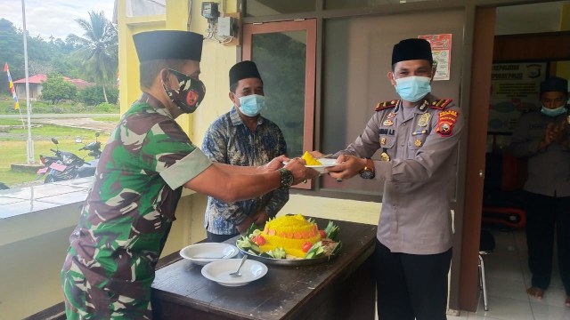 Kapolsek Saketa memotong tumpeng dalam syukuran HUT Bhayangkara. Foto: Dok. Polsek Saketa