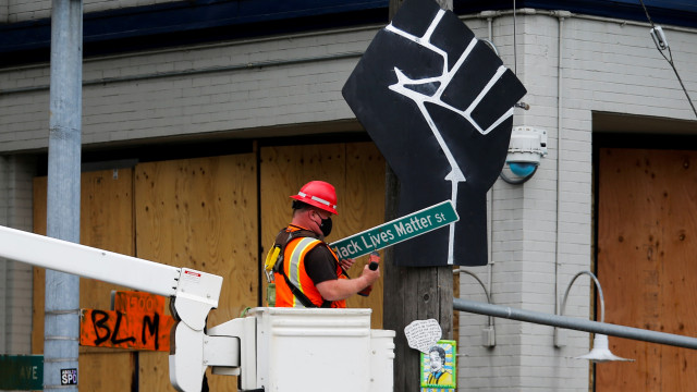 Pekerja membersihkan atribut demo di depan Kantor Polisi Seattle Timur, Seattle, Washington, Amerika Serikat. Foto: Lindsey Wasson/REUTERS