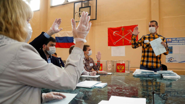 Anggota komisi pemilihan lokal mendiskusikan surat suara saat menghitung di TPS di Rusia. Foto: ANTON VAGANOV/Reuters