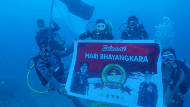 Peringati HUT Bhayangkara, 7 Penyelam Polda Gorontalo Kibarkan Bendera Merah Putih Dalam Air. Kamis, (2/7). Foto: Dok istimewa