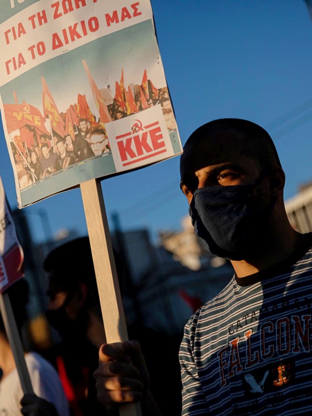 Anggota Partai Komunis Yunani (KKE) menegnakan masker saat demonstrasi menentang rencana pemerintah, di depan gedung parlemen di Athena, Yunani, Kamis (2/7). Foto: Alkis Konstantinidis/REUTERS