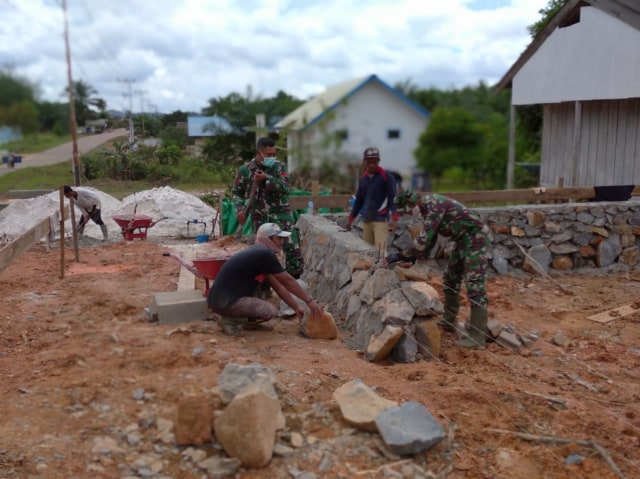 Satgas TMMD bersama warga bahu-membahu gotong-royong membangun pondasi Posko Terpadu di Desa Bangun Jaya. Joko Hardyono/InfoPBUN