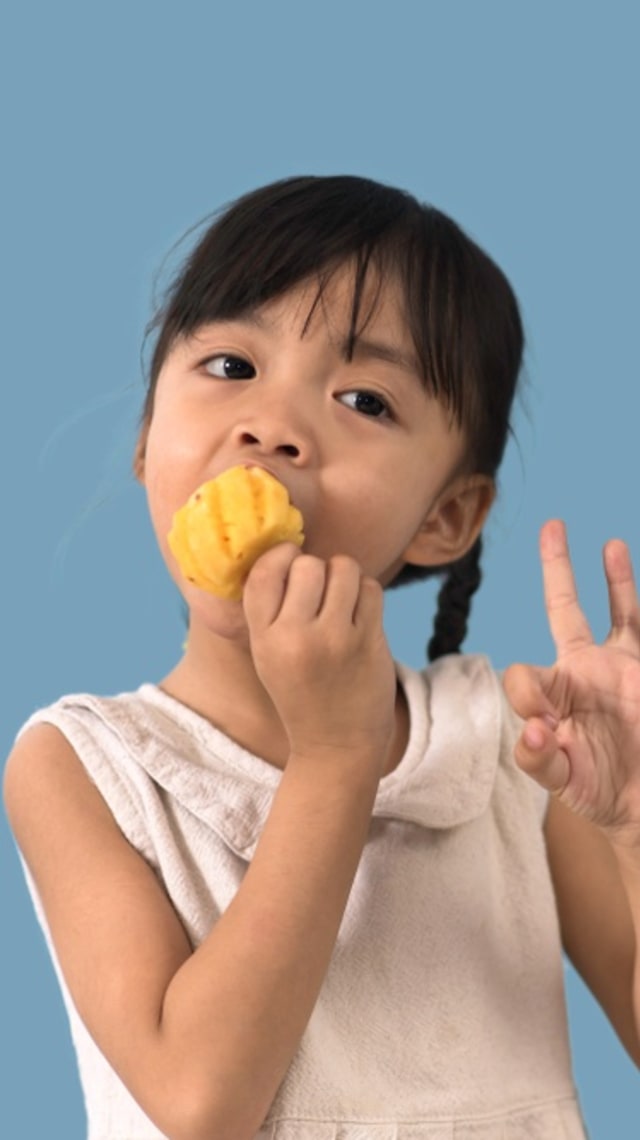 Anak makan nanas.
 Foto: Shutterstock
