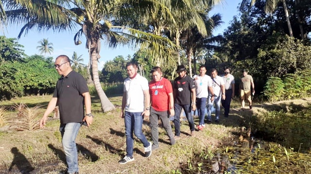 Calon Bupati Minahasa Utara dari PDI Perjuangan berjalan kaki melintasi perkebunan untuk bertemu dengan pengurus anak ranting PDI Perjuangan di  Watudambo