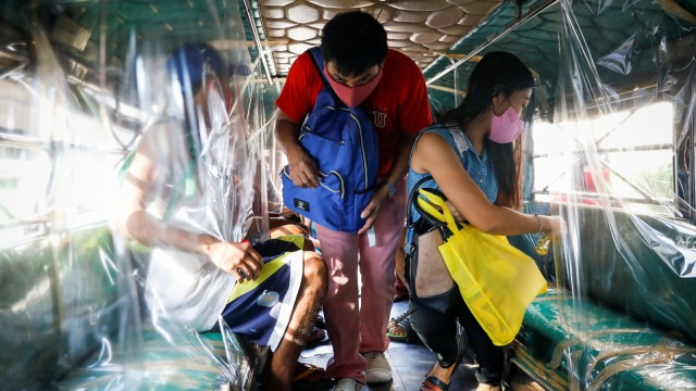 Seorang penumpang yang mengenakan masker naik ke jeepney di Kota Quezon, Metro Manila, Filipina. Foto: Eloisa Lopez/Reuters