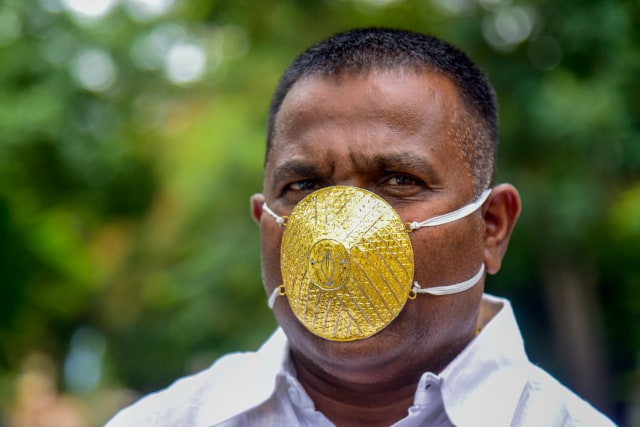 Pengusaha Shankar Kurhade memakai masker yang terbuat dari emas di tengah wabah virus corona di Pune, India. Foto: Sanket WANKHADE/AFP