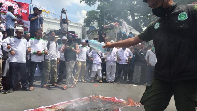 Massa yang demo menolak RUU HIP membakar bendera palu arit di depan Lapangan Merdeka, Medan, Sumatera Utara.  Foto: Rahmat Utomo/kumparan 