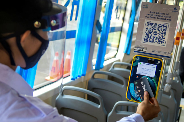 Karyawan menggunakan e-money di bus listrik saat uji coba di Kantor Pusat PT Transjakarta, Cawang, Jakarta, Senin (6/7). Foto: Galih Pradipta/ANTARA FOTO