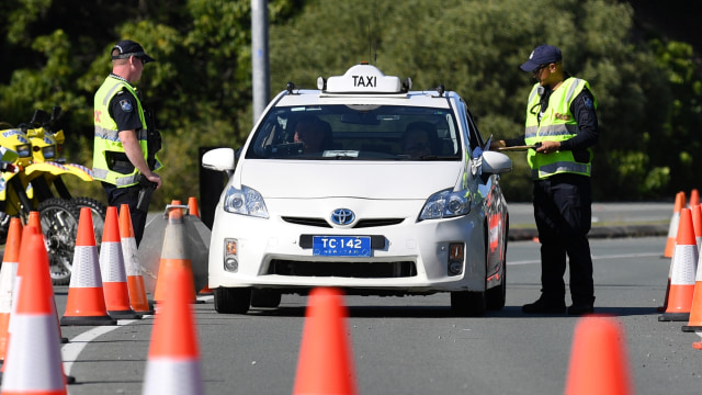Polisi memeriksa taksi di sebuah titik pemeriksaan di perbatasan Queensland-New South Wales di Coolangatta di Gold Coast. Foto: AAP Image/Dan Peled via Reuters