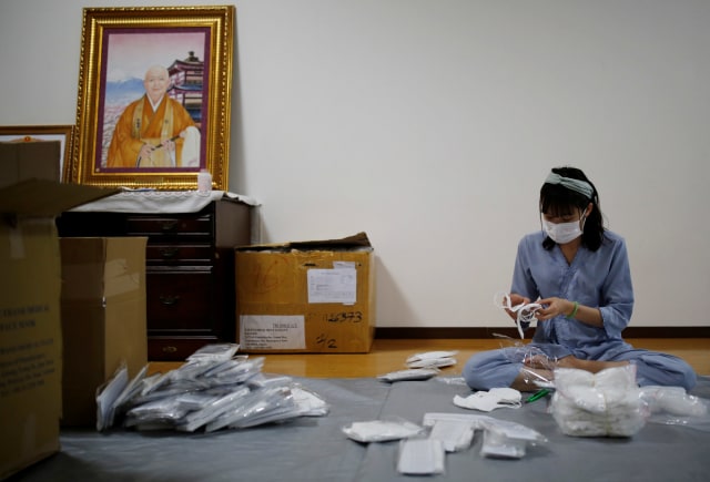 Salah satu pekerja migran menyiapkan masker di sebuah kuli Buddha di Tokyo yang menjadi tempat perlindungan selama wabah virus corona. Foto: KIM KYUNG-HOON/REUTERS