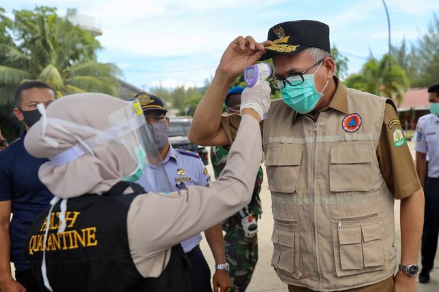 Plt Gubernur Aceh, Nova Iriansyah saat diperiksa suhu tubuh oleh tim Karantina Kesehatan Pelabuhan Ulee Lheu, Banda Aceh. Foto: Suparta/acehkini