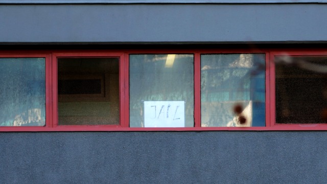 Sebuah tanda bertuliskan "penjara" terlihat di jendela apartemen di Melbourne, Negara Bagian Victoria, Australia, 8 Juli 2020. Foto: Sandra Sanders/REUTERS