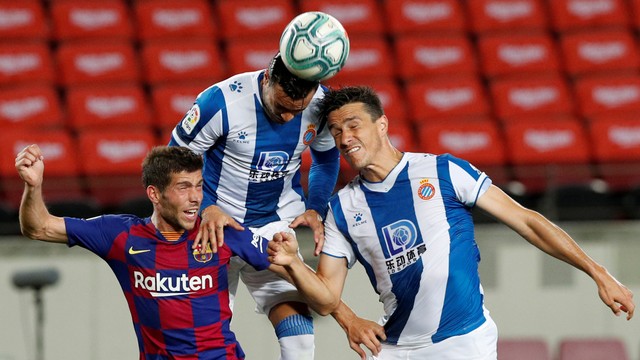 Pemain FC Barcelona Sergi Roberto berebut bola dengan pemain Espanyol pada lanjutan pertandingan La Liga di Stadion Camp Nou, Barcelona, Spanyol. Foto: Albert Gea/REUTERS